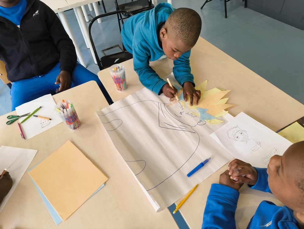 Un enfant en plein dessin pendant l'atelier Projet Ô