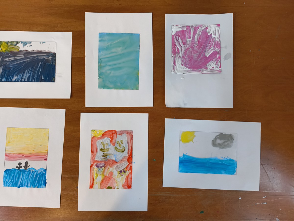Travaux d'atelier étalés sur une table, peintures et pastels