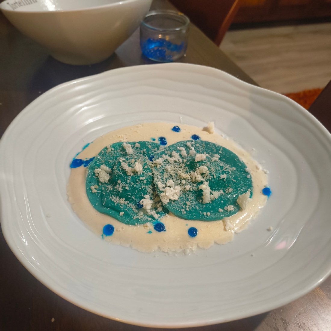 Ravioles turquoise et perles d'eau bleues sur crème d'amande